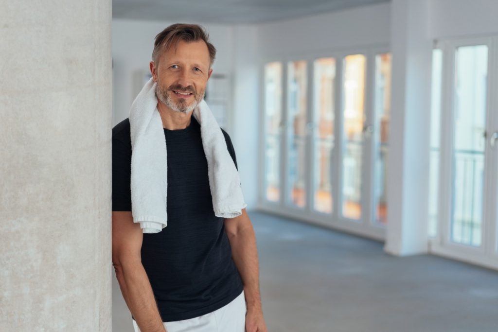 Confident and healthy man posing in the gym